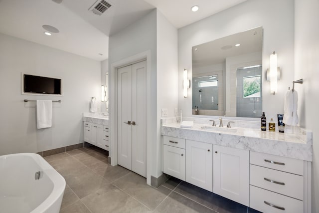 3912 Holland Ave, Dallas, TX 75219 - full bath with a tile shower, two vanities, a freestanding tub, recessed lighting, and baseboards
