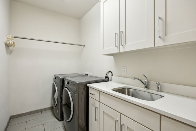3912 Holland Ave, Dallas, TX 75219 - washroom featuring cabinet space, washer and dryer, light tile patterned floors, and baseboards