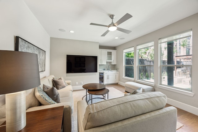3912 Holland Ave, Dallas, TX 75219 - living room with bar area, beverage cooler, baseboards, light wood finished floors, and ceiling fan