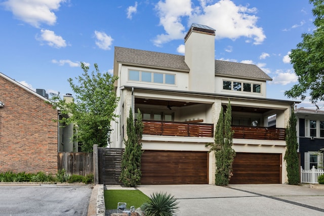 3912 Holland Ave, Dallas, TX 75219 - view of front of house with a balcony, stucco siding, a garage, concrete driveway, and fence