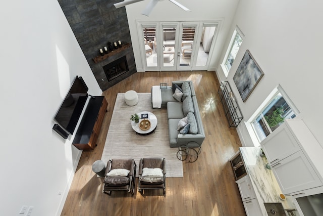 3912 Holland Ave, Dallas, TX 75219 - living area featuring wood finished floors, a fireplace, a towering ceiling, and healthy amount of natural light