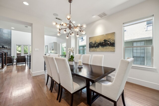 3912 Holland Ave, Dallas, TX 75219 - dining area with wood finished floors, a chandelier, baseboards, and recessed lighting