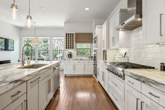 3912 Holland Ave, Dallas, TX 75219 - kitchen featuring wall chimney exhaust hood, a sink, light stone countertops, backsplash, and recessed lighting