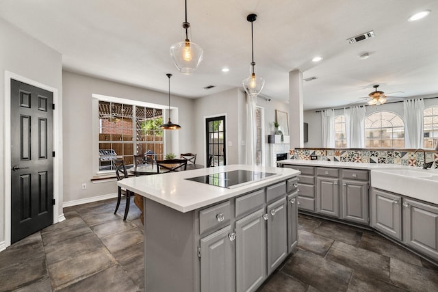 5800 Edgewood Dr, Mckinney, TX 75072 - kitchen featuring visible vents, a center island, light countertops, gray cabinetry, and black electric stovetop