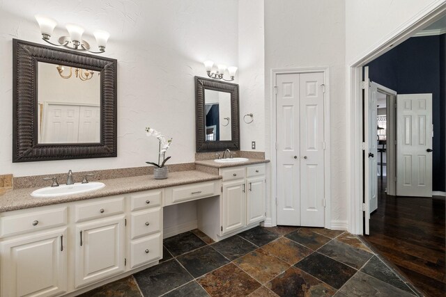 5800 Edgewood Dr, Mckinney, TX 75072 - bathroom featuring double vanity, a closet, a sink, and stone tile flooring