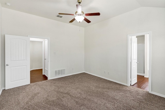 unfurnished bedroom featuring carpet floors, baseboards, vaulted ceiling, and visible vents