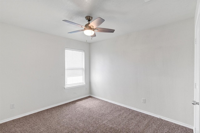 carpeted spare room with ceiling fan and baseboards