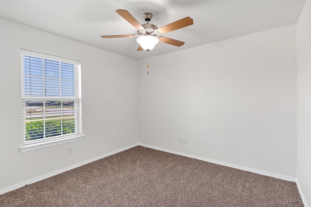carpeted empty room featuring ceiling fan and baseboards