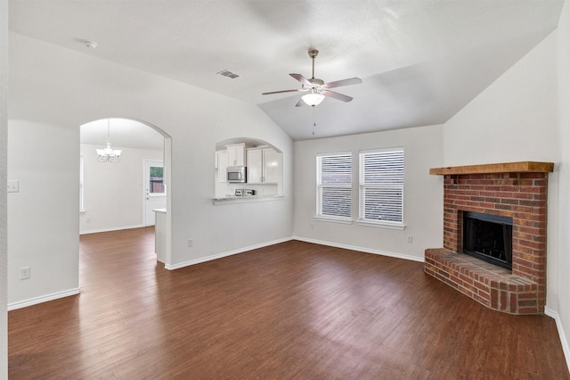 unfurnished living room with ceiling fan with notable chandelier, a fireplace, dark wood finished floors, visible vents, and lofted ceiling