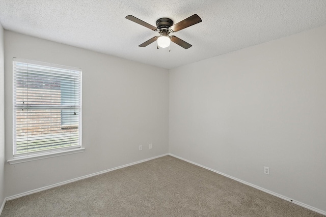 unfurnished room with baseboards, a ceiling fan, carpet, and a textured ceiling