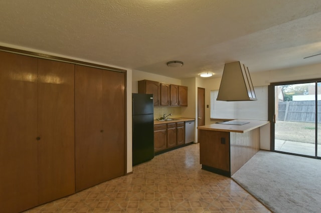 kitchen featuring dishwasher, light countertops, freestanding refrigerator, a peninsula, and a textured ceiling