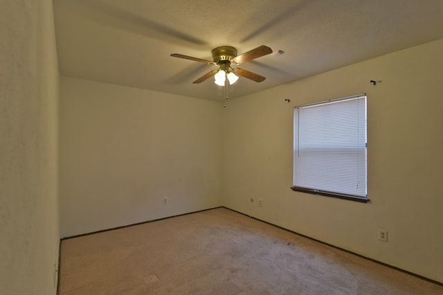 empty room featuring light carpet and a ceiling fan