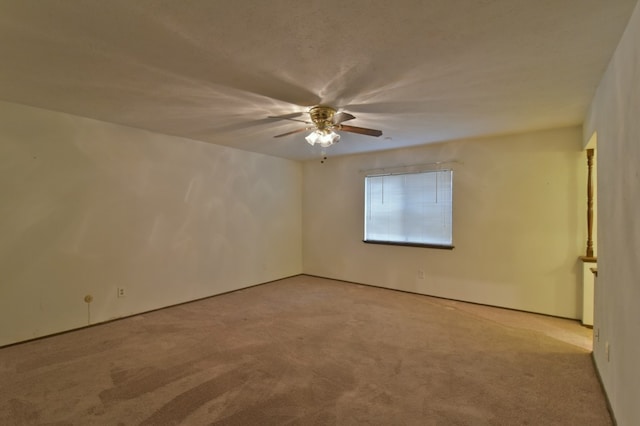 spare room with a ceiling fan and carpet flooring