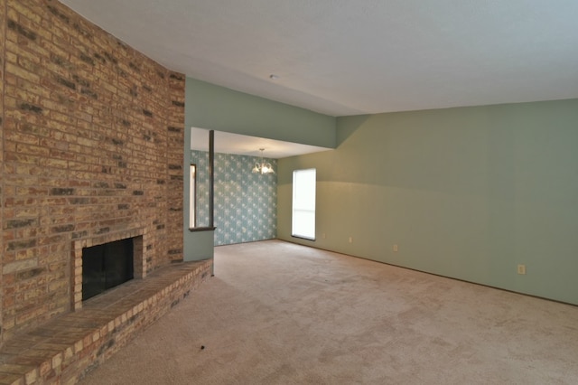 unfurnished living room featuring carpet and a brick fireplace