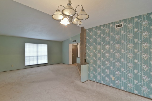 carpeted empty room with visible vents, a chandelier, and wallpapered walls