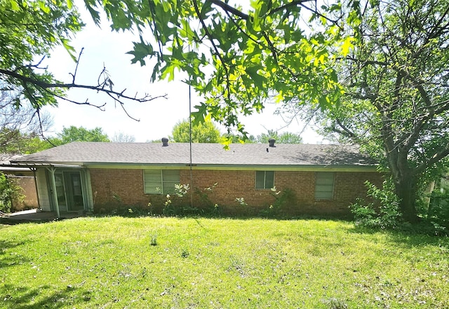rear view of house with a yard and brick siding
