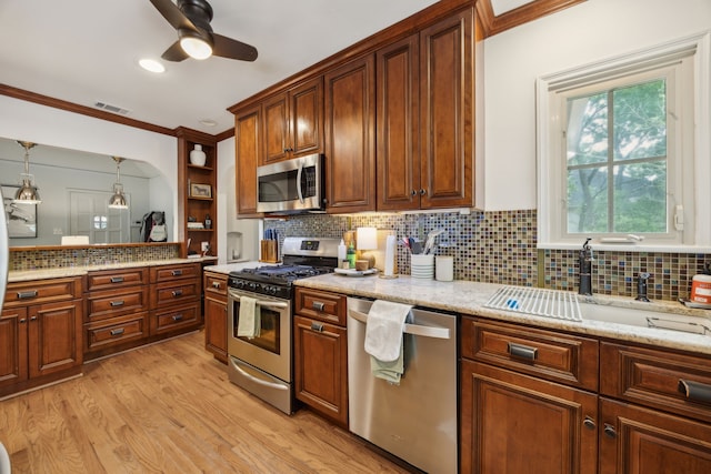 kitchen featuring stainless steel appliances, a sink, visible vents, backsplash, and a ceiling fan