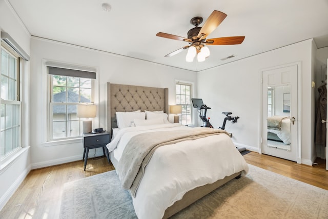 bedroom featuring light wood-type flooring, baseboards, and multiple windows