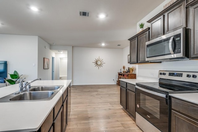 6427 Whitecap Dr, Princeton, TX 75407 - kitchen featuring appliances with stainless steel finishes, a sink, light wood-style floors, light countertops, and dark brown cabinetry
