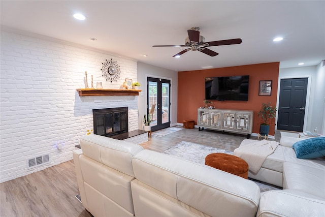 1711 Tamarack Dr, Dallas, TX 75228 - living room with wood finished floors, a ceiling fan, brick wall, a brick fireplace, and baseboards
