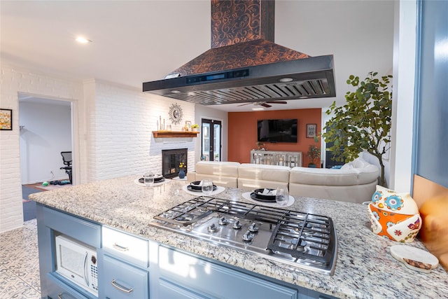 1711 Tamarack Dr, Dallas, TX 75228 - kitchen featuring a glass covered fireplace, stainless steel gas cooktop, blue cabinets, open floor plan, and extractor fan