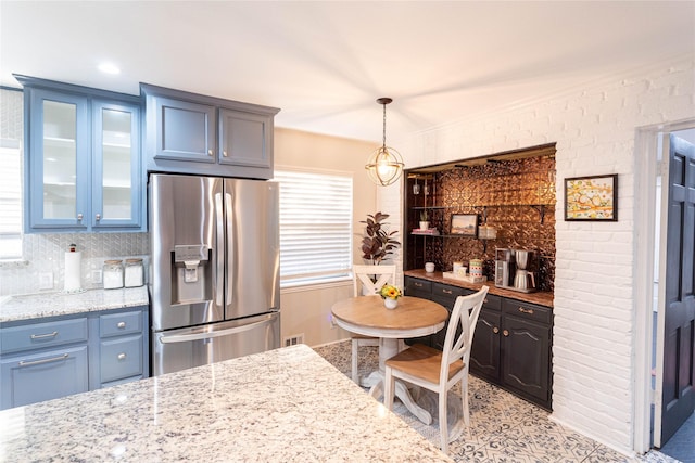 1711 Tamarack Dr, Dallas, TX 75228 - kitchen featuring stainless steel refrigerator with ice dispenser, glass insert cabinets, light stone counters, and decorative backsplash