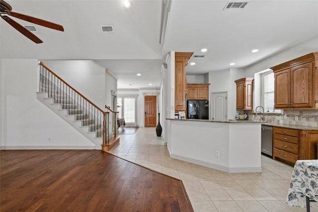 kitchen featuring black fridge with ice dispenser, ceiling fan, visible vents, and stainless steel dishwasher