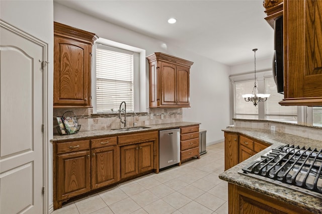 kitchen featuring a sink, decorative backsplash, brown cabinetry, and stainless steel appliances