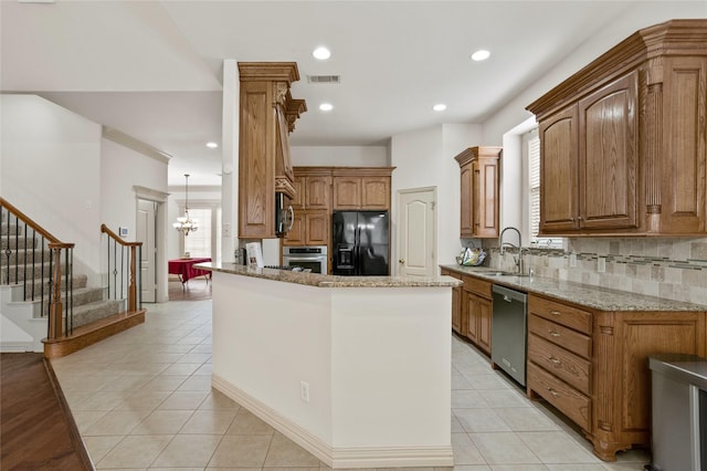 kitchen featuring an inviting chandelier, a sink, stainless steel appliances, tasteful backsplash, and visible vents