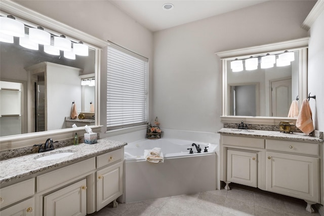 bathroom with a garden tub, a sink, two vanities, and tile patterned flooring