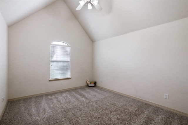 empty room with carpet flooring, a ceiling fan, baseboards, and vaulted ceiling