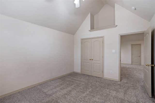 unfurnished bedroom with carpet floors, baseboards, a closet, and high vaulted ceiling