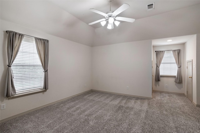 spare room with carpet flooring, ceiling fan, visible vents, and lofted ceiling