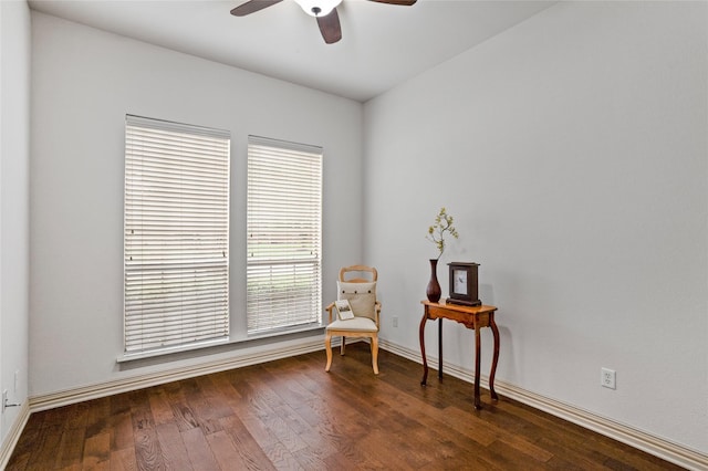sitting room with baseboards, ceiling fan, and dark wood-style floors