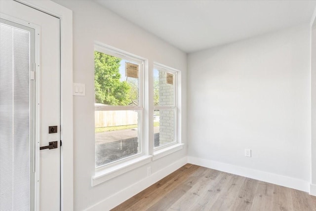 empty room with baseboards and wood finished floors