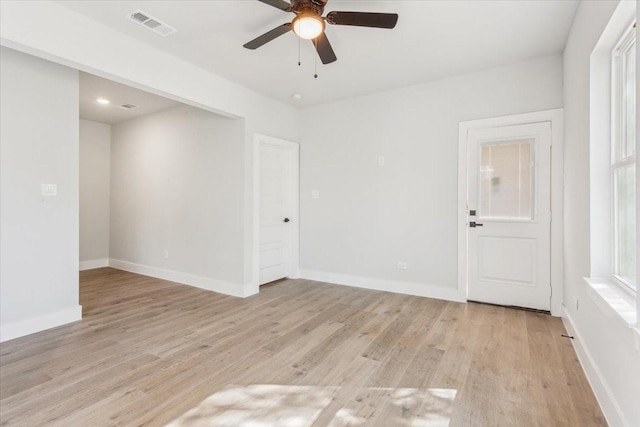 spare room with light wood-style flooring, baseboards, visible vents, and ceiling fan