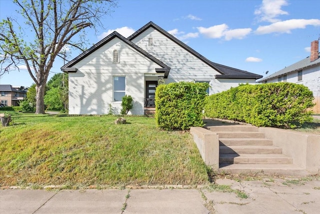 view of front of property featuring brick siding and a front lawn