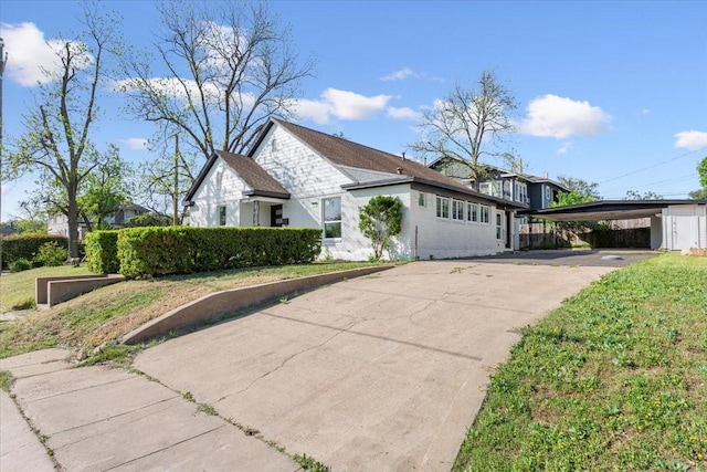 view of property exterior featuring concrete driveway and a carport
