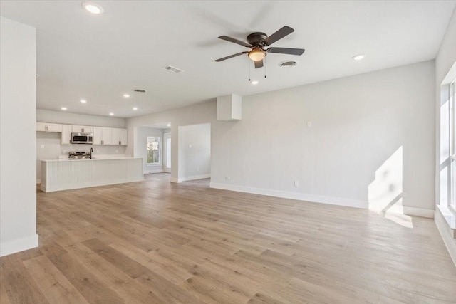 unfurnished living room featuring visible vents, baseboards, a ceiling fan, light wood-style floors, and recessed lighting