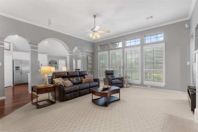 4009 Fairfax Ct, Flower Mound, TX 75028 - living room with ornate columns, ceiling fan, crown molding, arched walkways, and baseboards