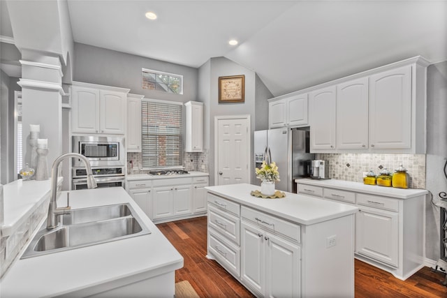 4009 Fairfax Ct, Flower Mound, TX 75028 - kitchen with stainless steel appliances, a sink, a center island, lofted ceiling, and backsplash