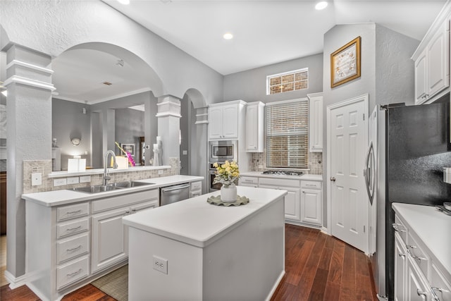 4009 Fairfax Ct, Flower Mound, TX 75028 - kitchen featuring a sink, ornate columns, appliances with stainless steel finishes, a center island, and tasteful backsplash