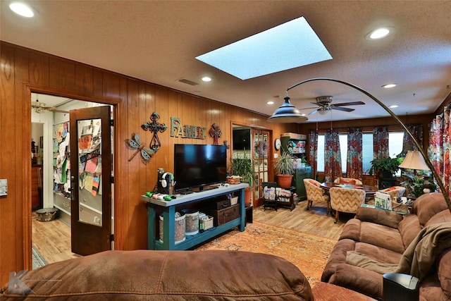 1929 S 13th St, Abilene, TX 79602 - living area featuring wooden walls, visible vents, ceiling fan, a skylight, and wood finished floors