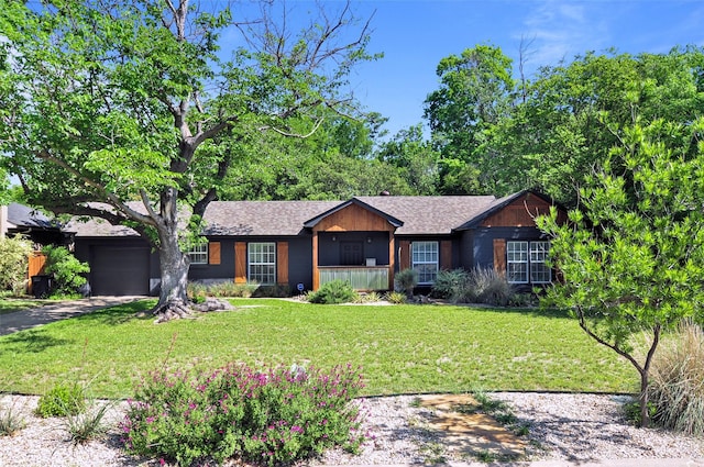 view of front of property featuring roof with shingles, aphalt driveway, an attached garage, and a front lawn