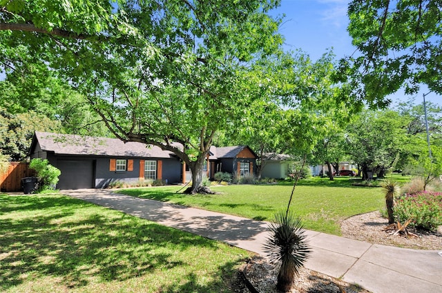 ranch-style house with a front yard, an attached garage, and driveway