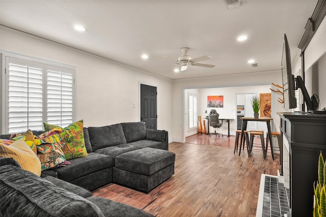 living area featuring wood finished floors, a ceiling fan, visible vents, and recessed lighting