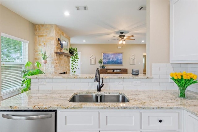 kitchen with visible vents, decorative backsplash, a ceiling fan, stainless steel dishwasher, and a sink
