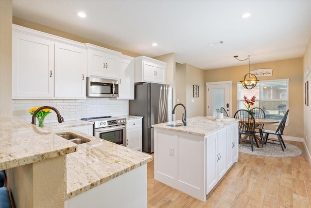 kitchen featuring a sink, appliances with stainless steel finishes, decorative backsplash, and white cabinetry