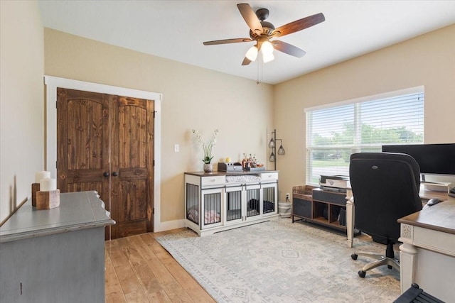 home office featuring baseboards, wood-type flooring, and a ceiling fan