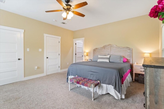 carpeted bedroom with baseboards, visible vents, and ceiling fan
